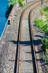 Obraz premium Railway that runs along the blue lake in the green mountains