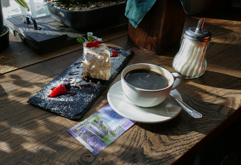 Kuwaiti banknotes lying under a cup of coffee 