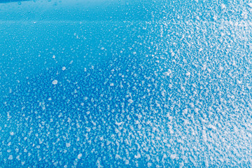 Sticky snow on the blue surface. Ice, cold.