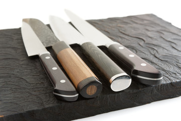 Set of new and used knives on wooden board