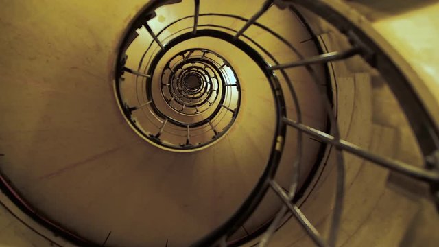 People climb the spiral staircase up. The concept of business growth with obstacles. Can be used as a prison in jail. Slow motion.