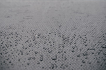 Water drops on car carbon. Dark wallpaper 