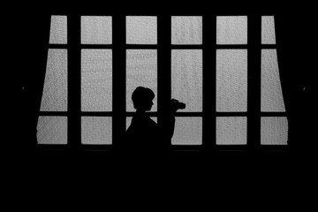 silhouette glass window home with woman