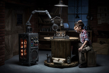 Boy with a robot helper playing chess