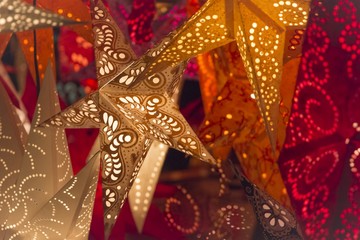 Colorful red golden orange christmas stars christmas market. Shiny red orange golden stars at european christmas market. The colours of the best miracle time of the year. Part of series