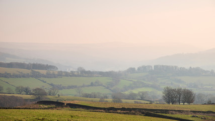 Fototapeta na wymiar Lovely landscape image of the Peak District in England on a hazy Winter day viewed from the lower slopes of Bamford Edge