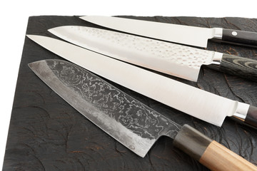 Four different knives on black cutting board
