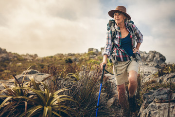 Adventurous senior woman on a hiking trip - obrazy, fototapety, plakaty
