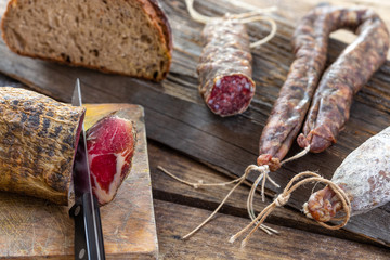 Local wild pork meat , delicatessen, made Corsica France wooden background