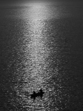 black and white silhouette man fishing in the sea with light sunset © srckomkrit