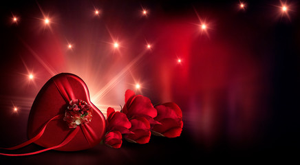 Romantic background with flowers, red roses and a box, a heart-shaped box. Night lanterns, the magical atmosphere of the evening. The scenery is romance. Love stories for women. Night view.