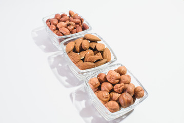 Peanuts, hazelnuts and almonds on a white background