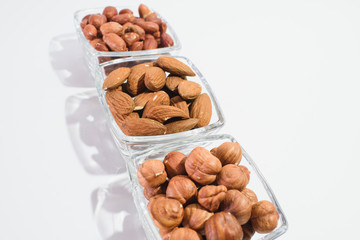 Peanuts, hazelnuts and almonds on a white background