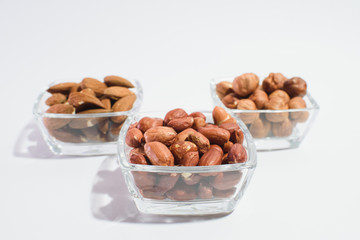 Peanuts, hazelnuts and almonds on a white background