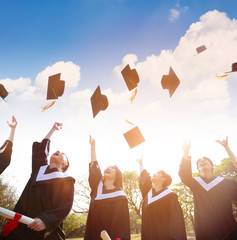 happy students throwing graduation caps in the Air