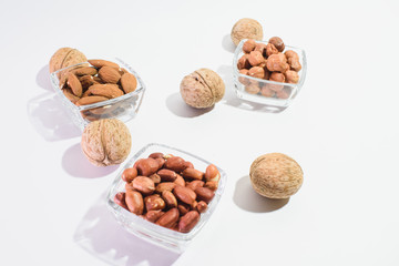 Peanuts, hazelnuts, almonds and walnuts on a white background