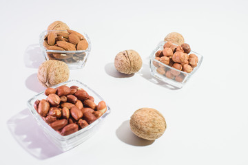 Peanuts, hazelnuts, almonds and walnuts on a white background