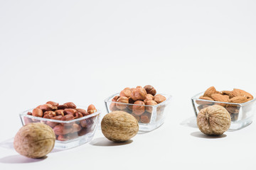 Naklejka na ściany i meble Peanuts, hazelnuts, almonds and walnuts on a white background