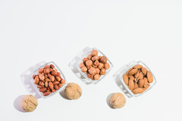 Peanuts, hazelnuts, almonds and walnuts on a white background