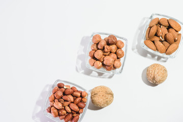 Peanuts, hazelnuts, almonds and walnuts on a white background