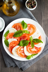 Close-up photo of caprese salad with ripe tomatoes, basil, buffalo mozzarella cheese. Italian and Mediterranean food concept. Fresh and healthy organic meal. Starter and antipasti. 