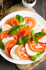 Close-up photo of caprese salad with ripe tomatoes, basil, buffalo mozzarella cheese. Italian and Mediterranean food concept. Fresh and healthy organic meal. Starter and antipasti. 