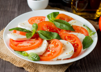 Close-up photo of caprese salad with ripe tomatoes, basil, buffalo mozzarella cheese. Italian and Mediterranean food concept. Fresh and healthy organic meal. Starter and antipasti. 