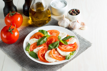 Close-up photo of caprese salad with ripe tomatoes, basil, buffalo mozzarella cheese. Italian and Mediterranean food concept. Fresh and healthy organic meal. Starter and antipasti. 