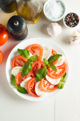 Close-up photo of caprese salad with ripe tomatoes, basil, buffalo mozzarella cheese. Italian and Mediterranean food concept. Fresh and healthy organic meal. Starter and antipasti. 
