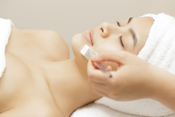 Obraz na płótnie Canvas Attractive young Asian woman getting facial treatment at the spa salon