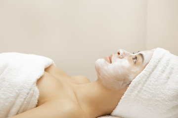 Obraz na płótnie Canvas Attractive young Asian woman getting facial treatment at the spa salon