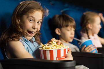 Group of happy kids enjoying a movie at the cinema