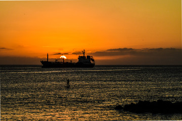 Ship with stand up paddle in sunset