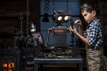 Young mechanic repairing the robot in his workshop