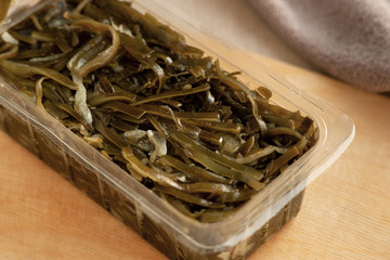Sea kale in the package. Laminaria in plastic packaging. Sea kale contains iodine for a healthy diet. Kelp on the kitchen table.