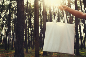 people holding cotton bag for mockup blank in nature background