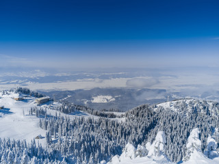 Winter mountains landscape, view from Postavaru peak (1799 m high) in Brasov, Romania, with Bucegi...