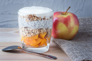 Healthy vanilla pudding of a chia in a glass with granola and a mango