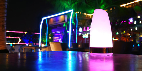 Night club, bar, cafe. Tropical beach club bar at night with purple, green, blue lights