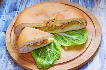 Delicious cabbage pie on wooden background.Homemade cake.