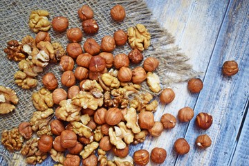 Delicious and healthy nuts on burlap, on a wooden background.
