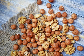 Delicious and healthy nuts on burlap, on a wooden background.