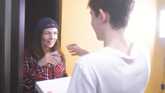 pizza delivery concept. woman delivers a box of pizza to the teenage boy . slow motion video. fast food concept lifestyle fast food delivery