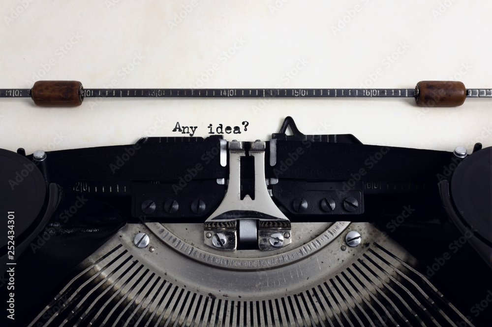 Fototapete old retro vintage black typewriter with close-up typing text question any idea as heading on aged pa