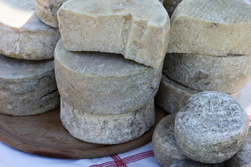 Various varieties of popular Georgian cheese, located on the street on a sunny day . Cheese consumption and production.