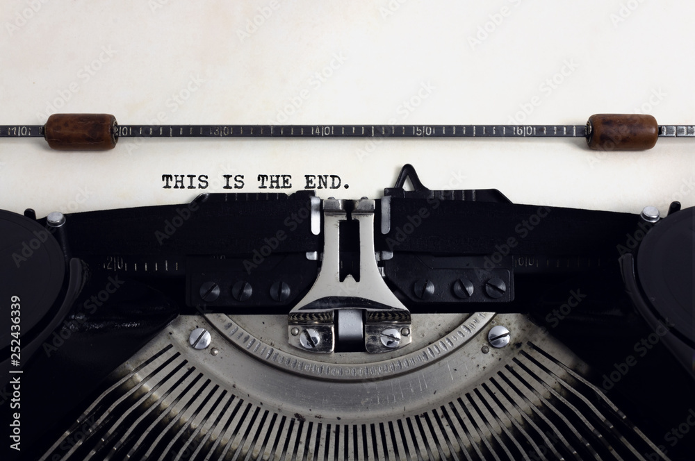Fototapete old retro vintage black typewriter with close-up typing text this is the end as heading on aged pape