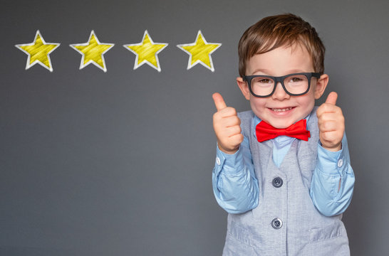 Cute little boy giving thumbs up with 4 stars approved