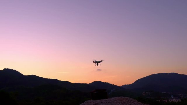 Drone quadcopters with high resolution digital camera Drone flying in sunset or sunrise beautiful sky
