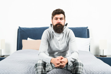 Tips for waking up early. Man bearded hipster sleepy face pajamas waking up bedroom interior. Daily schedule for healthy lifestyle. Rest and relax. Problem with early morning awakening. Get up early