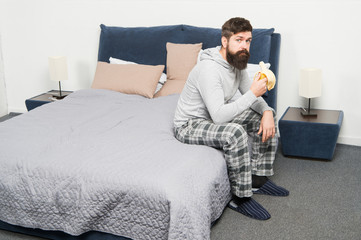 Man bearded hipster sleepy face pajamas waking up bedroom interior. Daily schedule for healthy lifestyle. Rest and relax. Problem with early morning awakening. Get up early. Tips for waking up early